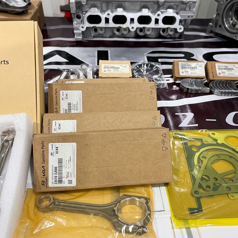 Cajas de piezas genuinas Hyundai y Kia con biela y juntas sobre la mesa