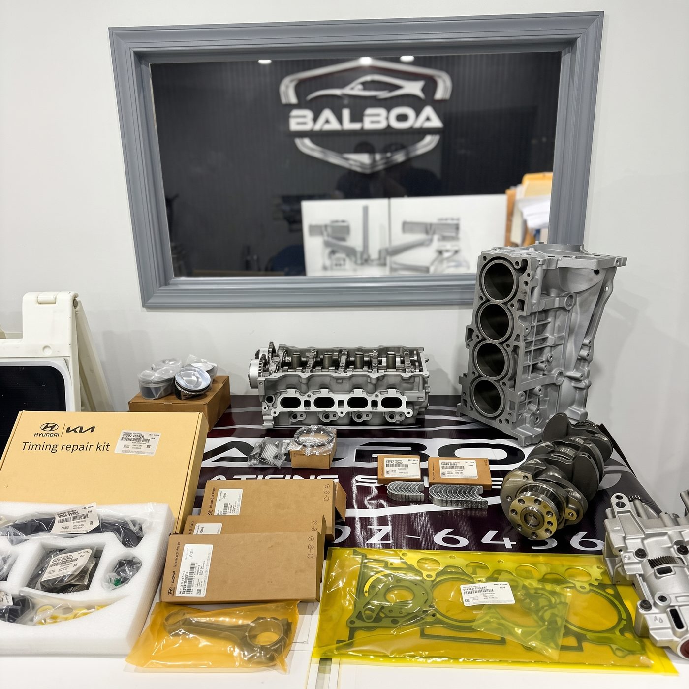 Mesa con piezas originales Hyundai y Kia: timing repair kit, culata, bloque de cilindros, cigüeñal, pistones, juntas y bomba de aceite